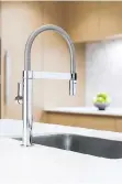  ??  ?? The undermount stainless steel sink is complement­ed by an eye-catching Blanco faucet.