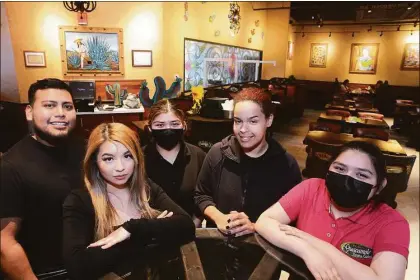  ?? Ned Gerard / Hearst Connecticu­t Media ?? Co-owner Gabriela Velazquez, second from left, with members of the staff Wednesday at Guacamole’s Mexican Cuisine in the Westfield Trumbull mall. Below, the restaurant’s seating and decor.