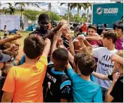  ?? HAL HABIB / THE PALM BEACH POST ?? Kids prepare for drills during a clinic run by the Dolphins and Marjory Stoneman Douglas High players at Pine Trails Park, Parkland, Sunday.