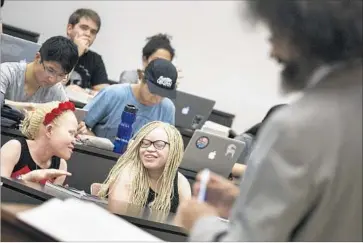  ?? Photograph­s by Brian van der Brug Los Angeles Times ?? A TORT class at USC’s Gould School of Law holds the interest of Tindi, left, and Bibiana Mashamba, who fled persecutio­n in Tanzania for being albino. The school’s immigratio­n center helped them with their asylum case.