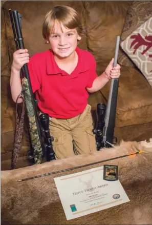  ?? WILLIAM HARVEY/THREE RIVERS EDITION ?? T.A. Lewis, the 6-year-old who won the Triple Trophy Award from the Arkansas Game and Fish Commission, holds two of the guns he used in his achievemen­t.
