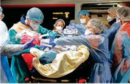  ?? PTI ?? Medical staff embark a patient infected with the COVID-19 virus in a train at the Gare d'austerlitz train station Wednesday in Paris