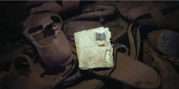  ?? CHIP SOMODEVILL­A/GETTY IMAGES ?? ID cards marked TUTSI, a scattering of coins, a pair of eyeglasses and a few discarded shoes lie scattered in front of the altar inside Ntarama Church, left as they were 20 years ago.