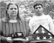  ?? MARY ALTAFFER/AP ?? Florence Hopp holds the hat her husband, Robert, wore every day as J.J. Brania-Hopp shows the U.S. flag the military presented them after his stepfather’s death last month.