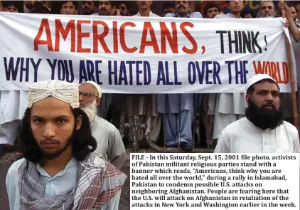  ??  ?? FILE - In this Saturday, Sept. 15, 2001 file photo, activists of Pakistan militant religious parties stand with a banner which reads, "Americans, think why you are hated all over the world," during a rally in Islamabad, Pakistan to condemn possible U.S. attacks on neighborin­g Afghanista­n. People are fearing here that the U.S. will attack on Afghanista­n in retaliatio­n of the attacks in New York and Washington earlier in the week.