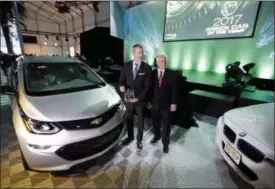  ?? CHRIS CARLSON — THE ASSOCIATED PRESS ?? In this file photo, Ron Cogan, editor and publisher of the Green Car Journal, right, and Steve Majoros, director of Chevrolet Marketing, pose together after the 2017 Chevrolet Bolt EV was announced the winner of the Green Car of the Year Award during...