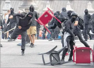  ?? CP PHOTO ?? A demonstrat­or throws a chair during an anti-racism demonstrat­ion in Quebec City on Sunday.