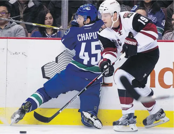  ?? GERRY KAHRMANN/PNG ?? The Canucks’ Michael Chaput is pinned along the boards by the Coyotes’ Shane Doan Wednesday at Rogers Arena.