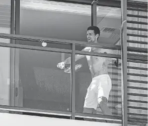  ?? MORGAN SETTE/ AFP VIA GETTY IMAGES ?? World No. 1 tennis player Novak Djokovic played on a balcony during the twoweek quarantine for the Australian Open.