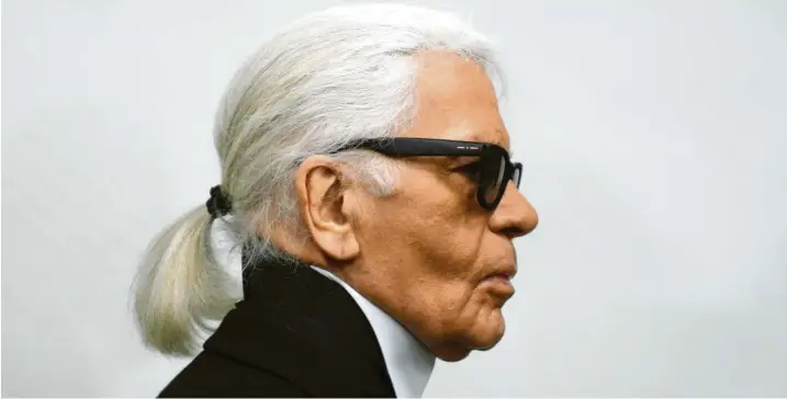  ?? Foto: Caroline Seidel, dpa ?? Sonnenbril­le, Pferdeschw­anz, dunkle Krawatte und der typische hohe Stehkragen – „Vatermörde­rkragen“genannt: Modeschöpf­er Karl Lagerfeld, hier 2014, hat sich selbst zur Marke gemacht.