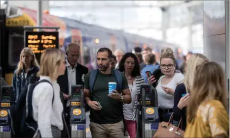  ??  ?? Commuters exit ticket barriers after arriving at London Waterloo railway station in London. Despite motor fuel prices rising to their highest since 2014 in the UK, annual consumer price inflation held in June at 2.4%, the Office for National Statistics (ONS) said yesterday.