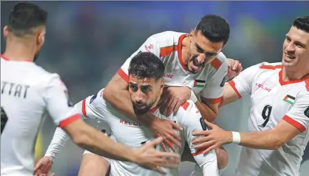  ?? AP ?? Palestine's Oday Dabbagh (center) celebrates with teammates after scoring in Palestine’s historic Group C win over Hong Kong, China, at Abdullah Bin Khalifa Stadium in Doha, Qatar, on Tuesday.
