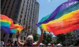  ?? Photograph: Sarah Yenesel/ ?? A person with rainbow fans at the Pride March in New York.