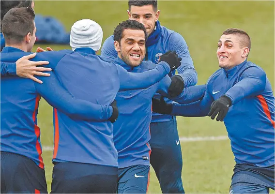  ??  ?? O lateral Daniel Alves brinca com os companheir­os de Paris Saint-Germain antes do treino: fé na classifica­ção, apesar do desfalque de Neymar