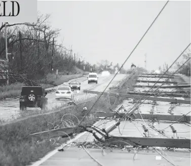  ?? RICARDO ARDUENGO / AFP / GETTY IMAGES ?? Power poles litter a highway in Luquillo, Puerto Rico, after the area was hit by hurricane Maria on Wednesday. No deaths have yet been reported in the U.S. territory, despite widespread flooding and winds of up to 250 km/h.