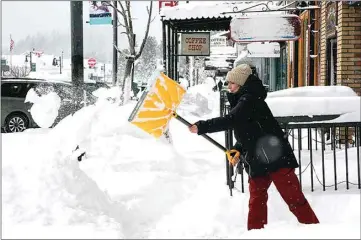  ?? ?? Snow is cleared from sidewalks in front of businesses during a snowstorm Saturday in downtown Truckee.