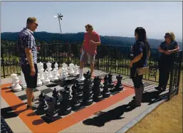  ?? JIM GENSHEIMER — STAFF ARCHIVES ?? Jeremiah Williams, left, of Capitola, and his brother, Jake Williams, of Baton Rouge, La., play a game of chess at Loma Prieta Winery in this file photo. Loma Prieta is among the Los Gatos wineries located in Santa Cruz County, which, unlike Santa Clara County, isn’t requiring that food be served with pours. The winery also has plentiful outdoor seating and so has reopened for tastings.