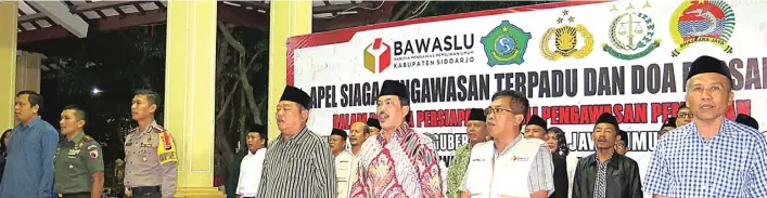  ?? MIFTAKHUL FS/BOY SLAMET/JAWA POS ?? MENUJU HARI H: Bupati Saiful Ilah dan jajaran Forkopimda Sidoarjo mengikui apel kesiapan pengawasan pilgub 2018 di Alun-Alun Sidoarjo pada Sabtu malam (23/6). Foto bawah, memasuki masa tenang, petugas mencopot spanduk paslon.