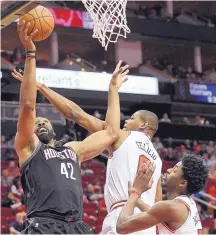  ?? ERIC CHRISTIAN/ASSOCIATED PRESS ?? Houston center Nene (42) shoots despite defensive pressure from Chicago’s Cristiano Felicio, center, and Justin Holiday. The Rockets won their 10th straight game.