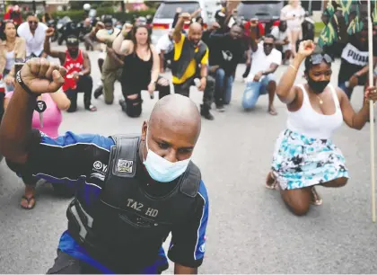  ?? ALLEN MCINNIS ?? Members of Montreal’s Black community and supporters take a knee and observe a minute of silence during a “Driving while Black” convoy and gathering that criss-crossed Montreal on Sunday.