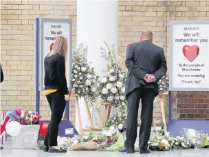  ?? People look at floral tributes at Manchester Victoria railway station which reopened on Tuesday, with services in the region returning to normal ??