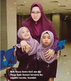  ??  ?? NUR Firuza Amira (kiri) dan Nur Firuza Aqila (kanan) bersama ibu saudara mereka, Yusnidah.