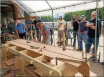  ?? PHOTO PROVIDED BY ELLIE BURHANS ?? At the June 3 “practice build” John Kaufman, wearing a blue shirt, left, and Tom Russell, grey shirt and bearded at right, begin working on the prototype for a 12-foot Carolina bateau which will be built by participan­ts in the 1st Annual Hudson River...