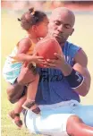  ?? AP FILE ?? Terance Mathis holds daughter Terae, then 18 months old, in 2000. She was a newborn when Mathis was in the Super Bowl.