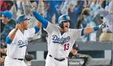  ?? MARK J. TERRILL/AP PHOTO ?? The Dodgers’ Max Muncy celebrates his game-winning home run against the Red Sox during the 18th inning early Saturday to give Los Angeles a 3-2 win over Boston in Game 3 of the World Series. Game 4 ended too late for this edition. Visit theday.com for a complete recap.