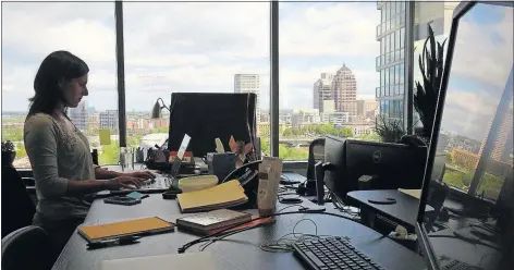  ?? [BROOKE LAVALLEY/ DISPATCH] ?? Kristen Kelly, a program manager for pharmacy, works at her desk at CoverMyMed­s in Downtown Columbus. The company, a startup in 2008, now employs more than 700 people and recently announced that it will hire hundreds more. It was sold earlier this year...