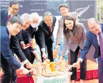  ?? Photos / Derek Cheng ?? Dancing kiwifruit, breaking wood on a sake barrel and the trailing press pack were all part of the Prime Minister’s trip to Singapore and Japan.