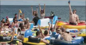  ?? MARK R. RUMMEL — THE TIMES HERALD VIA AP ?? People celebrate as they start the Float Down at Lighthouse Beach in Port Huron, Mich., Sunday. Thousands of people gathered for the event and floated down the St. Clair River.