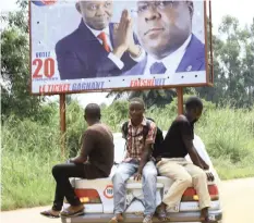  ?? AP ?? A CAR drives past an election campaign poster of Felix Tshisekedi, presidenti­al candidate of Congo’s Union for Democracy Party. Congolese officials have openly worried about the risks of holding an election on Sunday in a region where health officials fight to bring Ebola under control amid rebel attacks. |