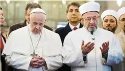  ?? — AP ?? ISTANBUL: Pope Francis (left) joins Grand Mufti of Istanbul Rahmi Yaran to pray in the Sultan Ahmet mosque yesterday.