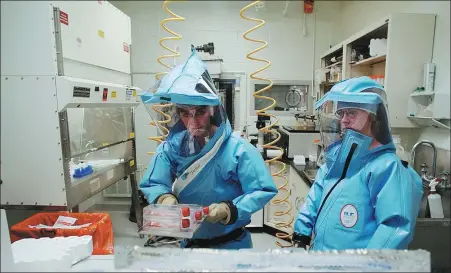  ?? OLIVIER DOULIERY / AGENCE FRANCE-PRESSE ?? Personnel at work in the biosafety level-4 laboratory at the US Army Medical Research Institute of Infectious Diseases at Fort Detrick in 2002.