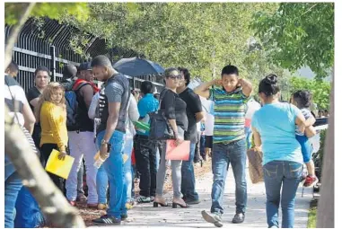  ?? TAIMY ALVAREZ/STAFF PHOTOGRAPH­ER ?? Immigrants including children stand for hours outside the federal Immigratio­n and Customs Enforcemen­t field office at 2805 SW 145th Ave. in Miramar. Advocates say people line up in the sun with no access to water, bathrooms or shade.