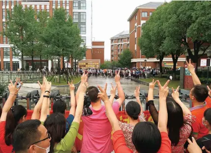  ??  ?? Teachers and parents wave to students as they enter an exam site at Shanghai Nanyang High School yesterday. About 50,000 students in Shanghai sat for the gaokao, China’s national college entrance exam, on Tuesday at 104 schools around the city. — Wang Rongjiang