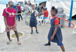  ?? ?? Children play with Hoola Hoops during the ‘Know Your Numbers’ screening campaign put on by the Ministry of Health and Wellness inside the St William Grant Park in downtown Kingston last Thursday.