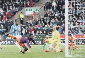  ??  ?? Raheem Sterling scores Manchester City’s second goal at Huddersfie­ld yesterday.