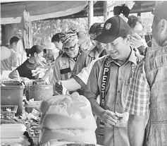  ??  ?? Gerawat (second right) visits stalls at the festival ground.