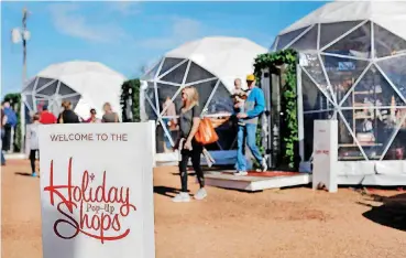  ?? [PHOTO BY JIM BECKEL, THE OKLAHOMAN] ?? Local retailers are taking turns occupying domes at Midtown’s Holiday Pop-Up shops at NW 10 and Hudson in Oklahoma City. Saturday, people are encouraged to visit the Pop-Up shops and other local retailers as part of Small Business Saturday.
