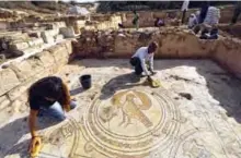  ??  ?? Timnah Goloubin, left, an archaeolog­ist with the Israel Antiquitie­s Authority, shows a mosaic church floor of an Eagle symbol of the Byzantine Empire.