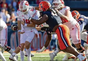  ?? MICHAEL HICKEY/GETTY IMAGES/TNS ?? Illinois defensive tackle JerZhan “Johnny” Newton pops Wisconsin quarterbac­k Braedyn Locke, forcing a fumble. Newton tops the list of defensive tackle prospects for this year’s NFL draft.