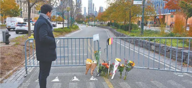  ?? AFP/TIMOTHY A. CLARY ?? Flores em homenagem às oito vítimas de terça-feira foram colocadas nas grades que marcam o ponto onde Sayfullo Saipov entrou na ciclovia com sua caminhonet­e alugada. Ao fundo, o World Trade Center