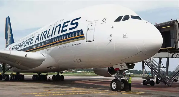  ?? — AFP ?? Turbulent times: A Singapore Airlines Airbus A380 plane is seen at Changi Airport. The A380 has battled against sluggish sales, squeezed by smaller, more efficient twin-engined jets.