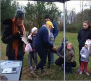  ?? PHOTOS BY GLENN GRIFFITH ?? Tori Herkalo, center in yellow ball cap, of the Wilton Wildlife Preserve and Nature Center shows a snapping turtle’s shell to one of the early group’s at last Saturday’s “Things That Go Bump In the Night” nature walk in Clifton Park. At left Erin McCabe gathers up a second shell to show the group