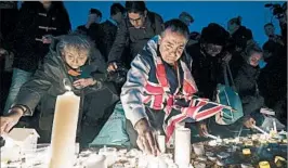  ?? CARL COURT/GETTY ?? People hold a London vigil Thursday after an attack for which ISIS claimed responsibi­lity.