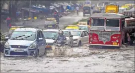  ?? PTI ?? Vehicles wade through waterlogge­d roads during a downpour in Mumbai on Monday.