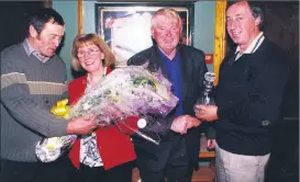  ?? ?? Liam Reidy (second right) making a presentati­on to Michael Fitzgerald, who had retired from his position as manager of Araglin Creamery in 2001, pictured with Bill Russell, who is presenting a bouquet of flowers to Michael’s wife Bridie at the function held in O’Mahony’s Bar.