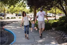  ?? JUAN ANTONIO LABRECHE FOR THE NEW MEXICAN ?? Brady, Brittany and 20-monthold Clara Griffith walk last month toward the columbariu­m where Brady and Brittany’s deceased son Liam’s ashes rest at Faith Lutheran Church in Albuquerqu­e.